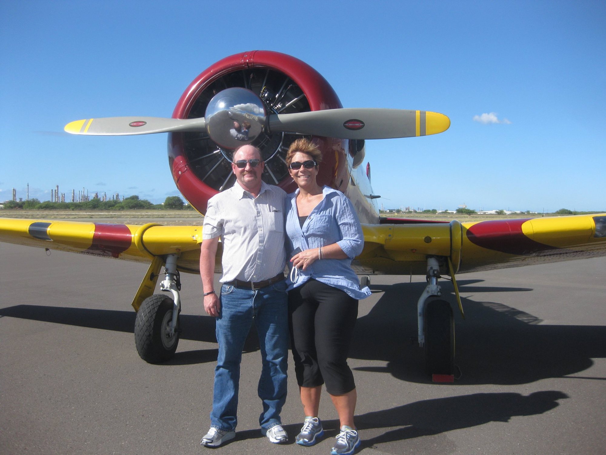 a propeller plane that is parked on the side of a road