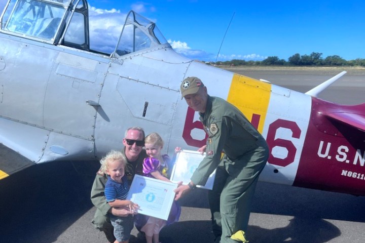 a group of people standing around a plane