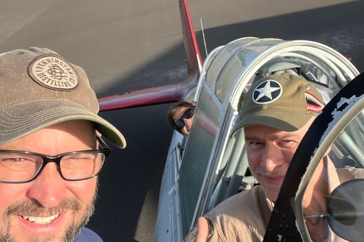 a man wearing a hat and sunglasses posing for the camera