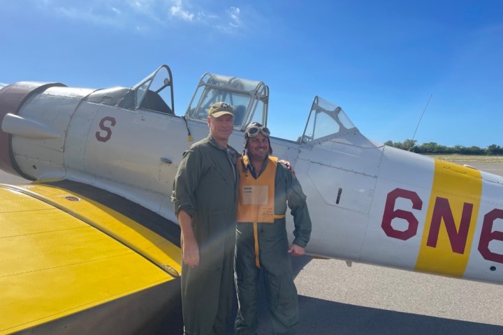 a man standing next to a plane